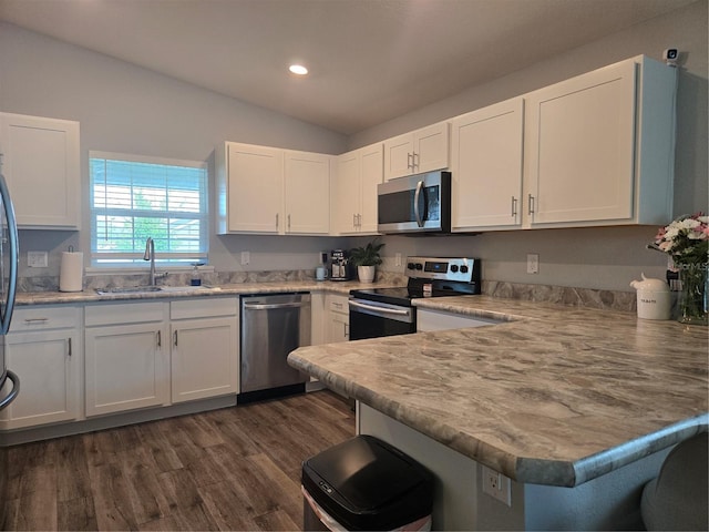 3003 58th Way E, Palmetto, FL 34221 - kitchen featuring stainless steel appliances, a sink, a peninsula, white cabinetry, and lofted ceiling