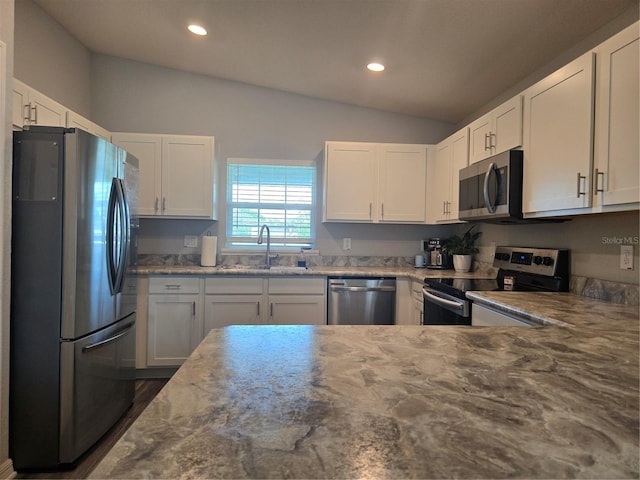 3003 58th Way E, Palmetto, FL 34221 - kitchen featuring stainless steel appliances, a sink, vaulted ceiling, recessed lighting, and white cabinetry