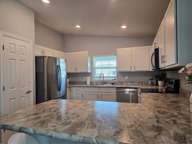 3003 58th Way E, Palmetto, FL 34221 - kitchen with stainless steel appliances, lofted ceiling, a sink, recessed lighting, and white cabinets