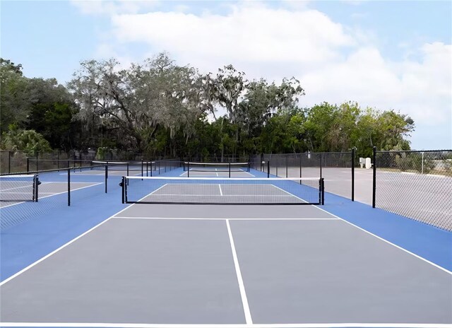 3003 58th Way E, Palmetto, FL 34221 - view of tennis court with community basketball court, fence, and view of wooded area