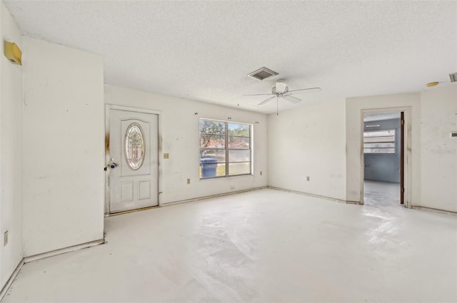 entryway with a textured ceiling, a ceiling fan, and unfinished concrete flooring