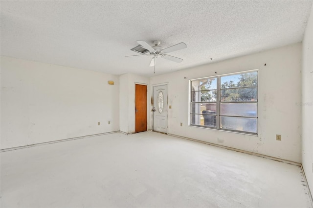 spare room with a textured ceiling and a ceiling fan