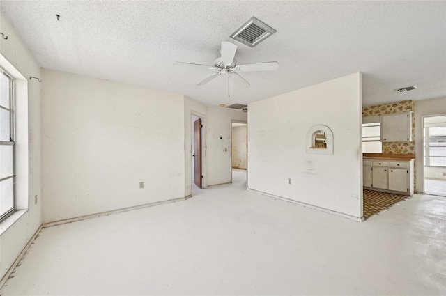 unfurnished room with concrete flooring, ceiling fan, and a textured ceiling