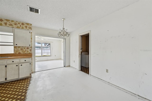 unfurnished dining area with a chandelier, concrete floors, and a textured ceiling
