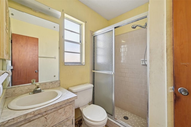 full bath featuring a stall shower, toilet, and vanity