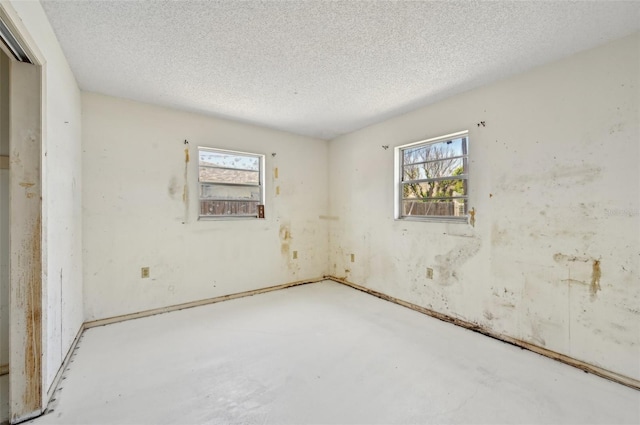 unfurnished room featuring concrete flooring and a textured ceiling