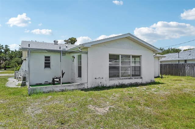 rear view of house featuring stucco siding