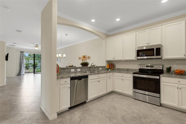 9823 Haze Dr, Venice, FL 34292 - kitchen featuring appliances with stainless steel finishes, a sink, stone countertops, light tile patterned floors, and a chandelier