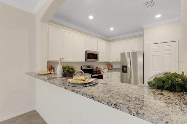 9823 Haze Dr, Venice, FL 34292 - kitchen featuring stainless steel appliances, light stone counters, crown molding, white cabinets, and recessed lighting