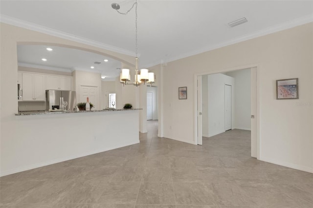 9823 Haze Dr, Venice, FL 34292 - kitchen featuring appliances with stainless steel finishes, a chandelier, crown molding, white cabinetry, and arched walkways