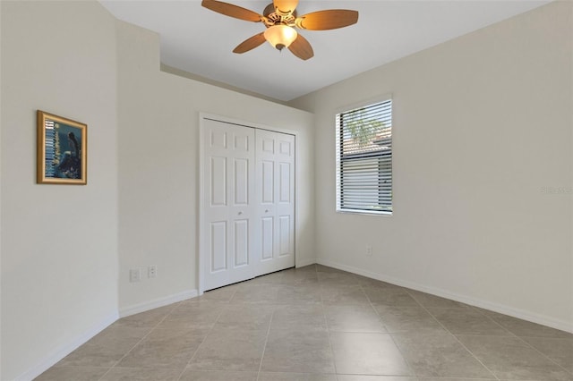 9823 Haze Dr, Venice, FL 34292 - unfurnished bedroom with a closet, light tile patterned floors, baseboards, and ceiling fan