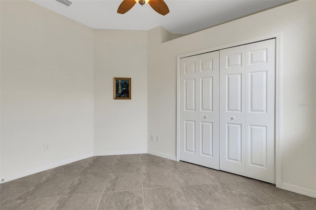 9823 Haze Dr, Venice, FL 34292 - unfurnished bedroom featuring light tile patterned flooring, a closet, a ceiling fan, and baseboards
