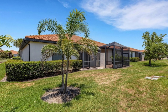 9823 Haze Dr, Venice, FL 34292 - rear view of house featuring a tile roof, a yard, a lanai, and stucco siding