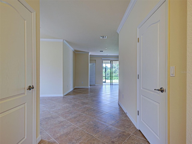 hallway with crown molding, baseboards, and tile patterned floors