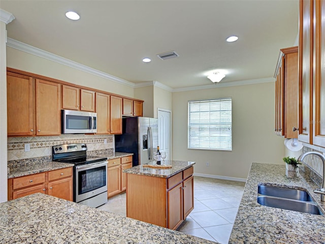 kitchen with stainless steel appliances, a sink, a center island, tasteful backsplash, and crown molding