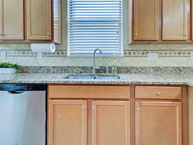 kitchen featuring dishwasher, a sink, tasteful backsplash, and light stone countertops