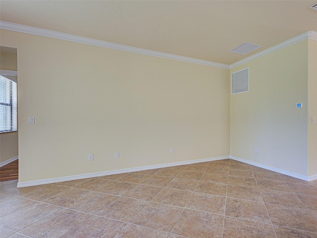 empty room featuring ornamental molding, light tile patterned floors, and baseboards