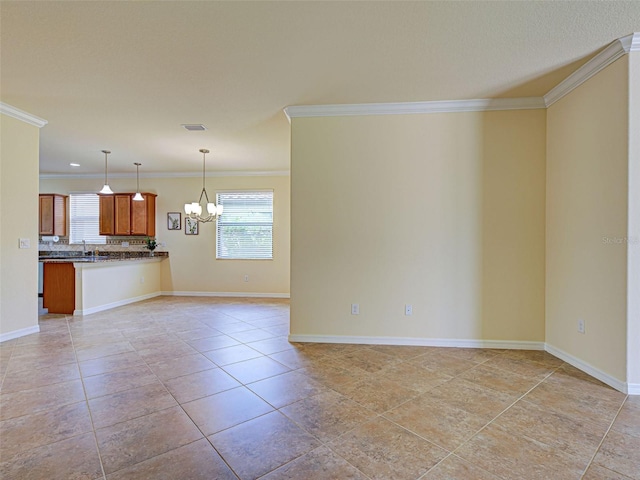 kitchen with open floor plan, a chandelier, plenty of natural light, dark countertops, and ornamental molding