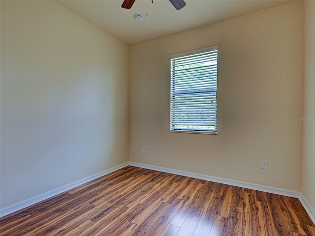 spare room with ceiling fan, wood finished floors, and baseboards