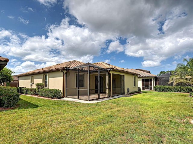 back of property featuring stucco siding, a yard, and a tile roof