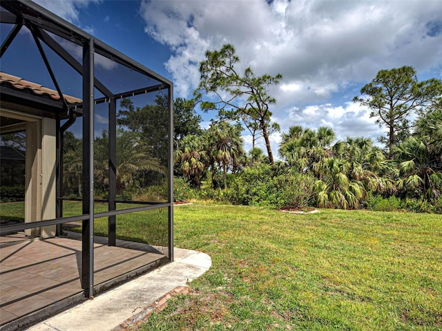 view of green lawn with glass enclosure