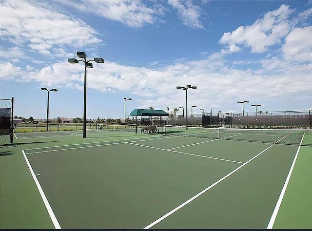 view of tennis court with fence and community basketball court