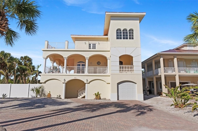 63 Palm Dr, Placida, FL 33946 - view of front of home with stucco siding, a balcony, decorative driveway, fence, and a garage