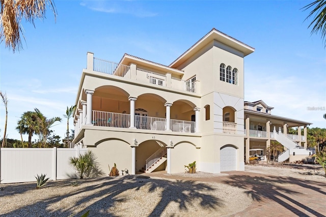 63 Palm Dr, Placida, FL 33946 - view of front facade with a balcony, stairway, decorative driveway, fence, and a garage