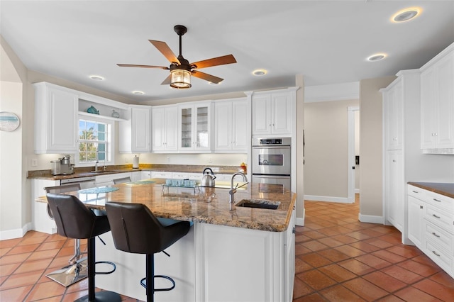 63 Palm Dr, Placida, FL 33946 - kitchen with double oven, a sink, white cabinets, stovetop, and recessed lighting