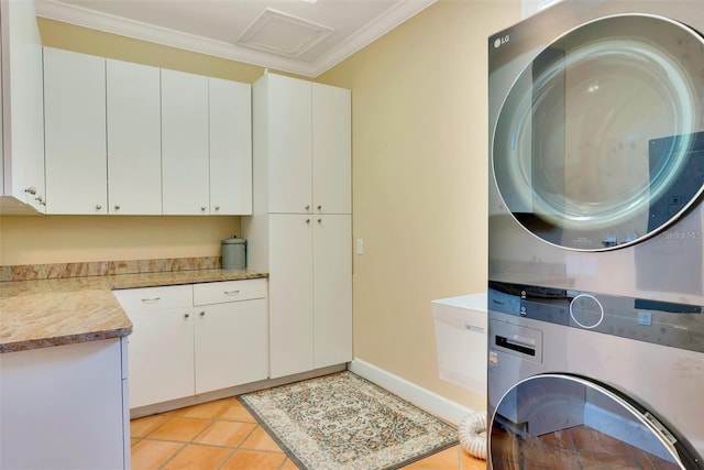 63 Palm Dr, Placida, FL 33946 - washroom featuring cabinet space, stacked washing machine and dryer, crown molding, light tile patterned floors, and attic access