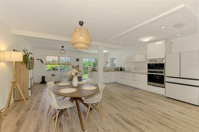 4321 Shamrock Dr, Venice, FL 34293 - dining area featuring light wood finished floors and a textured ceiling