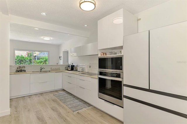4321 Shamrock Dr, Venice, FL 34293 - kitchen with stainless steel appliances, a sink, modern cabinets, backsplash, and a textured ceiling