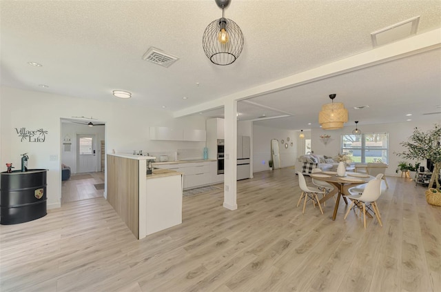 4321 Shamrock Dr, Venice, FL 34293 - kitchen with modern cabinets, light wood-style floors, hanging light fixtures, a textured ceiling, and recessed lighting