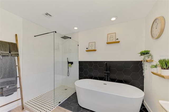 4321 Shamrock Dr, Venice, FL 34293 - bathroom featuring a walk in shower, a freestanding bath, tile walls, and recessed lighting