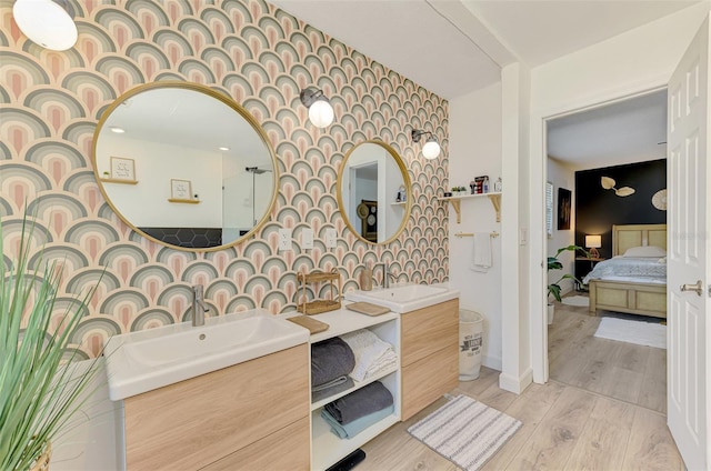 4321 Shamrock Dr, Venice, FL 34293 - ensuite bathroom with wood finished floors, two vanities, wallpapered walls, and an accent wall