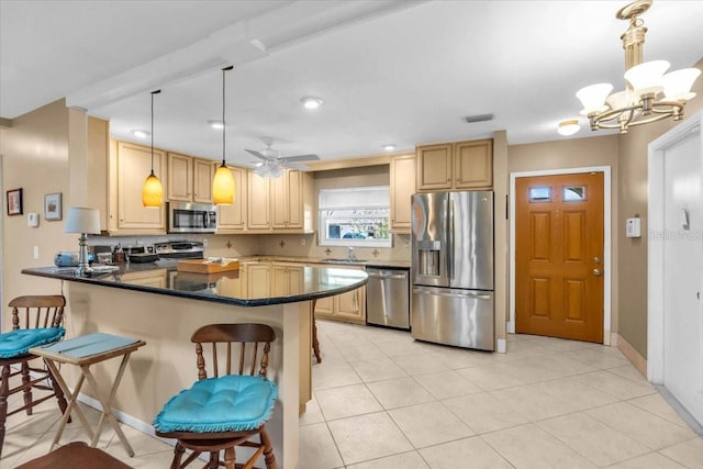 2618 Titania Rd, Englewood, FL 34224 - kitchen featuring appliances with stainless steel finishes, a sink, tasteful backsplash, a peninsula, and dark countertops