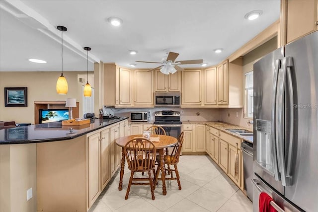 2618 Titania Rd, Englewood, FL 34224 - kitchen featuring appliances with stainless steel finishes, cream cabinetry, a sink, ceiling fan, and decorative light fixtures