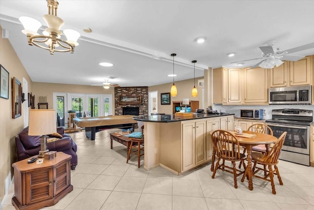 2618 Titania Rd, Englewood, FL 34224 - kitchen featuring stainless steel appliances, open floor plan, a ceiling fan, dark countertops, and a chandelier