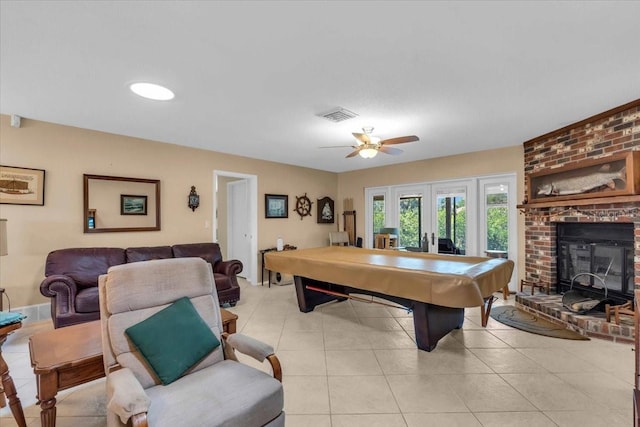 2618 Titania Rd, Englewood, FL 34224 - game room with french doors, light tile patterned floors, a ceiling fan, and a brick fireplace