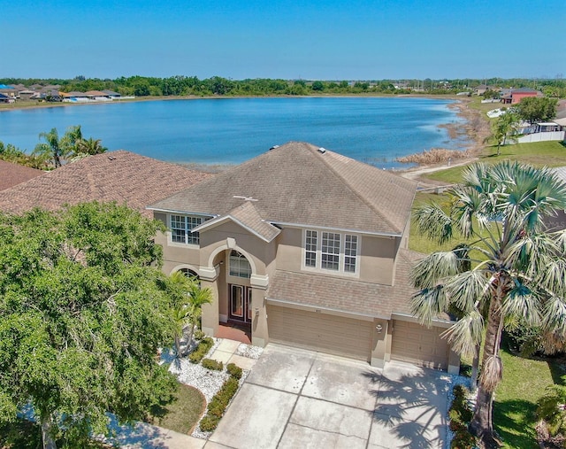 632 Tanana Fall Dr, Ruskin, FL 33570 - view of front of house with stucco siding, roof with shingles, an attached garage, driveway, and a water view