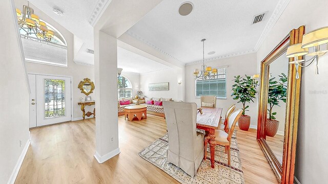 632 Tanana Fall Dr, Ruskin, FL 33570 - dining space with light wood-style flooring, a chandelier, ornamental molding, and baseboards