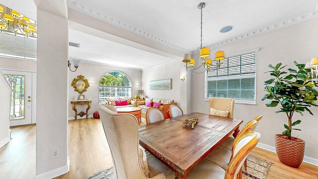 632 Tanana Fall Dr, Ruskin, FL 33570 - dining area featuring a chandelier, light wood-type flooring, baseboards, and ornamental molding