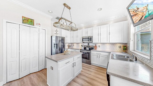 632 Tanana Fall Dr, Ruskin, FL 33570 - kitchen with appliances with stainless steel finishes, a sink, ornamental molding, backsplash, and white cabinetry