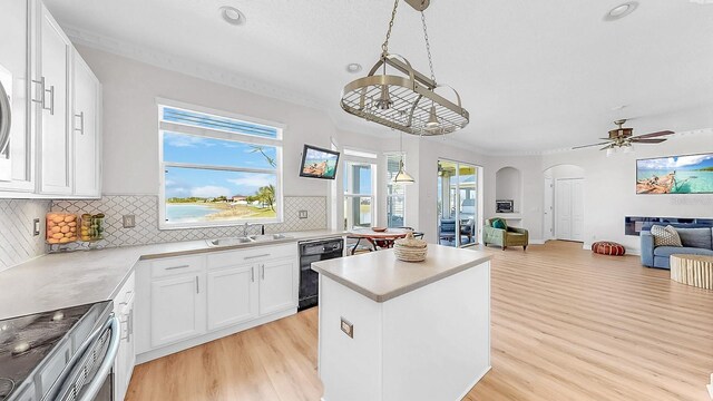 632 Tanana Fall Dr, Ruskin, FL 33570 - kitchen featuring arched walkways, dishwasher, stainless steel range with electric cooktop, light wood-style floors, and a sink