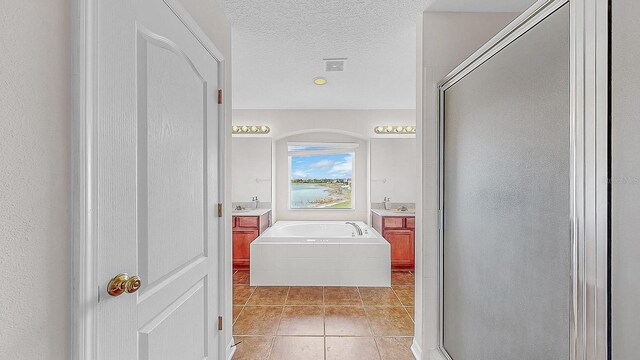 632 Tanana Fall Dr, Ruskin, FL 33570 - full bath with a stall shower, tile patterned flooring, vanity, a garden tub, and a textured ceiling
