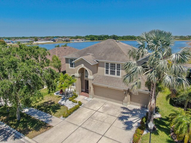 632 Tanana Fall Dr, Ruskin, FL 33570 - view of front facade with stucco siding, a garage, roof with shingles, driveway, and a water view
