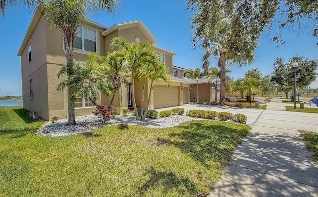 632 Tanana Fall Dr, Ruskin, FL 33570 - view of front of property featuring stucco siding, concrete driveway, a garage, and a front lawn
