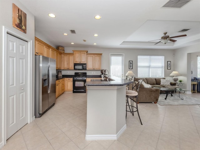 165 Tiziano Way N, Venice, FL 34275 - kitchen featuring black appliances, open floor plan, dark countertops, a breakfast bar area, and light tile patterned floors