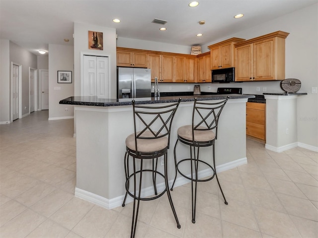 165 Tiziano Way N, Venice, FL 34275 - kitchen with stainless steel fridge with ice dispenser, black microwave, a kitchen island with sink, baseboards, and recessed lighting