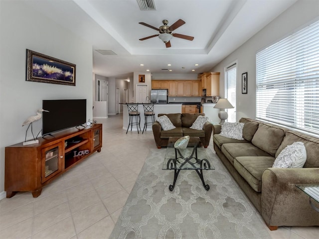 165 Tiziano Way N, Venice, FL 34275 - living room featuring a ceiling fan, a raised ceiling, recessed lighting, light tile patterned floors, and baseboards